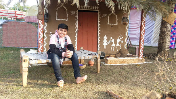 istock Boy in India sits Outside his Club House. 1202181524