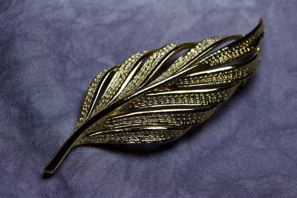 istock Vintage golden leaf brooch on gray silk background 1202183708