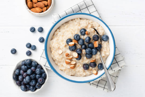 porridge di farina d'avena con noci e mirtilli nella vista dall'alto della ciotola - almond bowl ceramic food foto e immagini stock