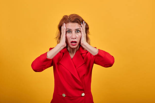 istock Shocked caucasian young woman keeping hands on cheeks, looking confused 1202186055