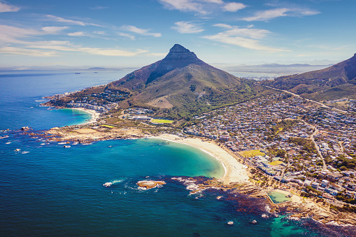 Aerial drone point of view towards the famous Cape Town Districts and Beaches of Camps Bay, Camps Bay Beach, Clifton and Signal Hill Mountain under beautiful summer cloudscape. Camps Bay (in the center) is a famous suburb of the city of Cape Town with famous Camps Bay Beach, white sandy beaches right underneath the Table Mountain. Clifton - Signal Hill -Camps Bay, Cape Town, South Africa, Africa