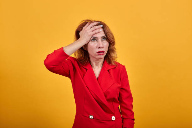 istock Shocked caucasian young woman keeping hand on forehead, confused 1202189893