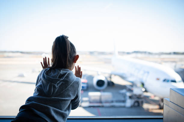 istock Child looking at airplane from airport window 1202189914