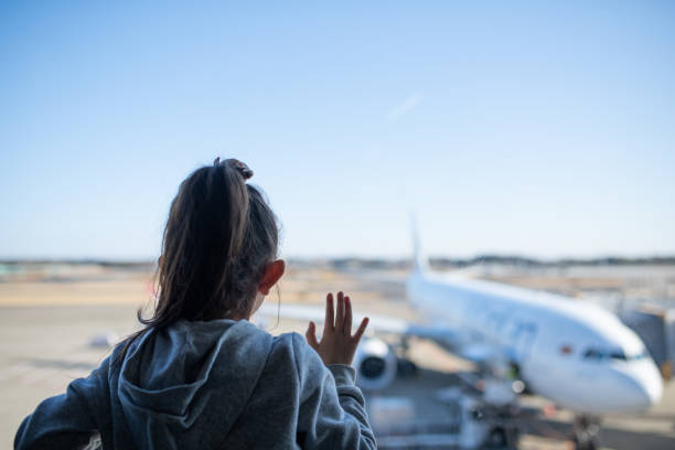 istock Child looking at airplane from airport window 1202189915