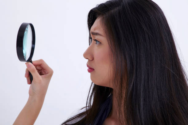istock woman using magnifying glass on the white background 1202202803