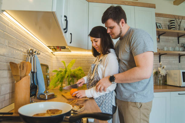 istock lovely couple hugging on the kitchen while cooking breakfast 1202203708