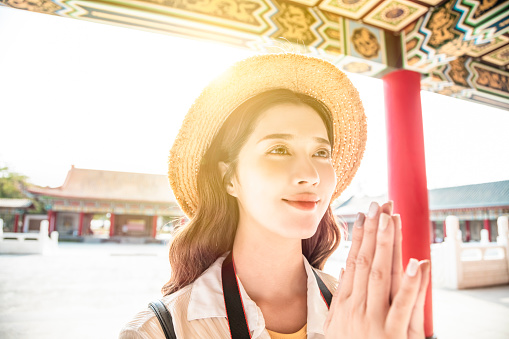 tourist young woman praying at chinese temple