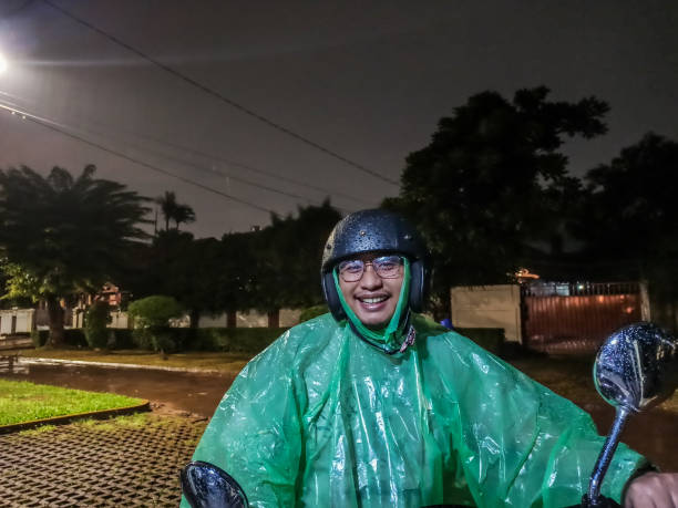 istock Asian Man with Raincoat, Riding Motorcycle 1202209237