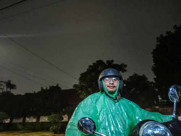 istock Asian Man with Raincoat, Riding Motorcycle 1202209238