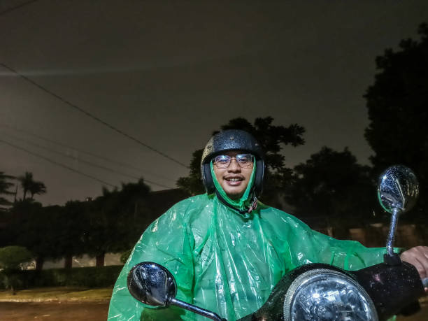 istock Asian Man with Raincoat, Riding Motorcycle 1202209341