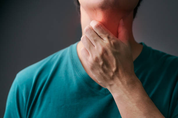 unhappy asian man using his hand touching on his neck suffering from gland inflammation. adult man feels bad on a sore throat and sick from cold, flu. throat pain, sickness, healthcare, and medical concept. - touching neck imagens e fotografias de stock