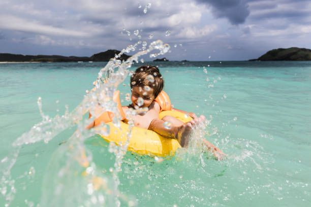 istock Carefree boy having fun while floating on water in inflatable ring. 1202213490