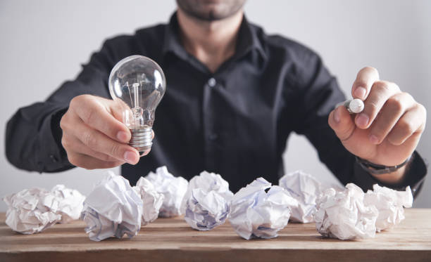 istock Man holding light bulb and writing in screen. Concept of inspiration and creativity 1202214268