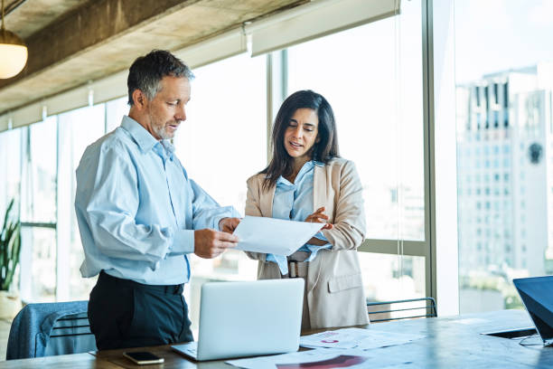 istock Colleagues discussing over report in office 1202215056