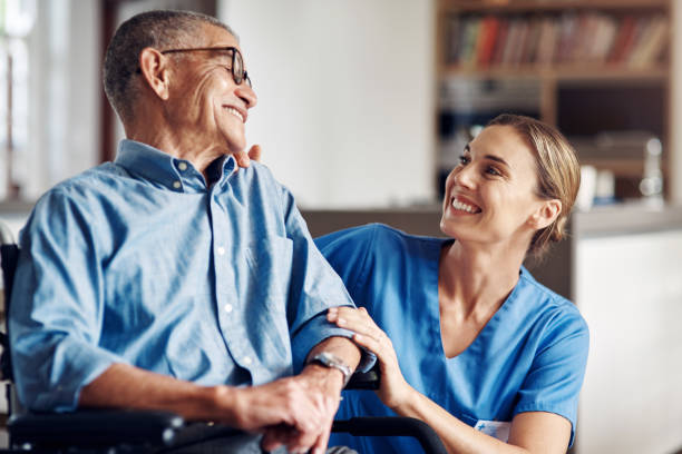 I'm so happy you're happy Shot of a senior man in a wheelchair being cared for by a nurse at home home caregiver photos stock pictures, royalty-free photos & images