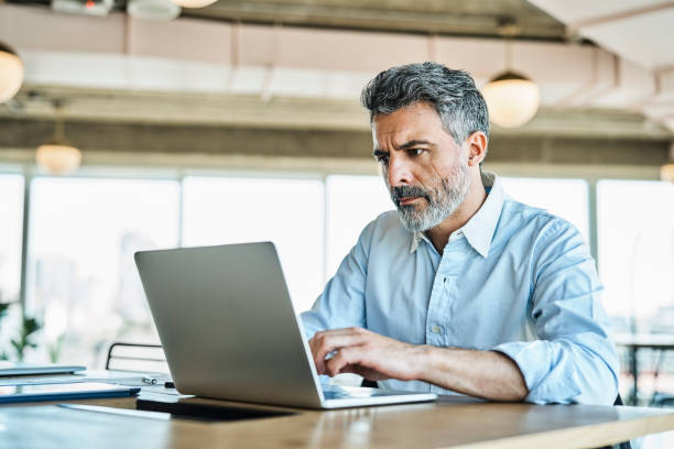 istock Confident businessman using laptop in office 1202215119