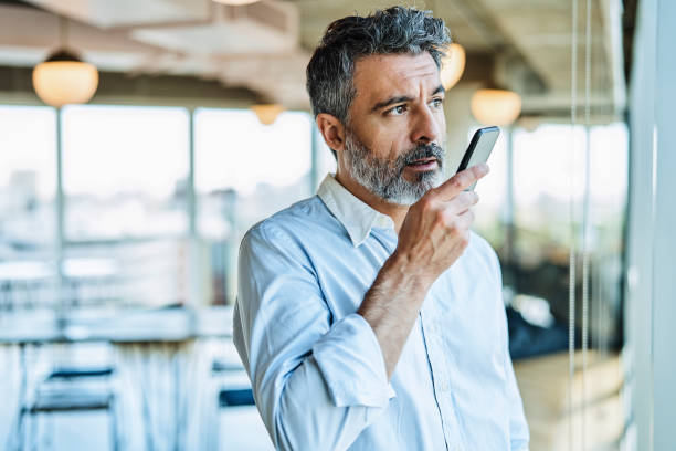 Businessman talking through mobile phone speaker