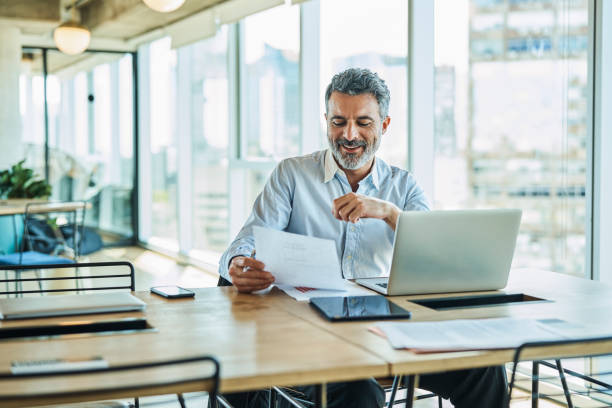 confident businessman working at coworking space - paper document notebook laptop imagens e fotografias de stock