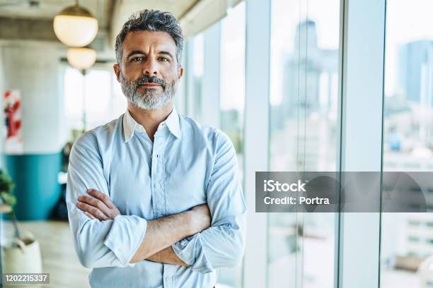 Confident Businessman With Arms Crossed In Office Stock Photo - Download Image Now - Men, Portrait, Businessman