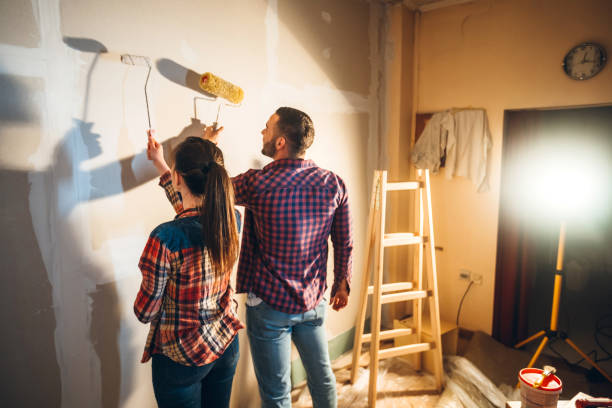 istock Young couple painting wall 1202217432