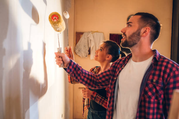 istock Young couple painting wall 1202217508