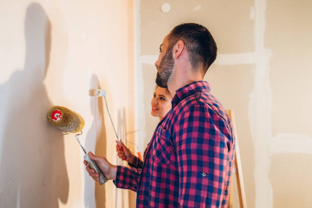 istock Young couple painting wall 1202217518