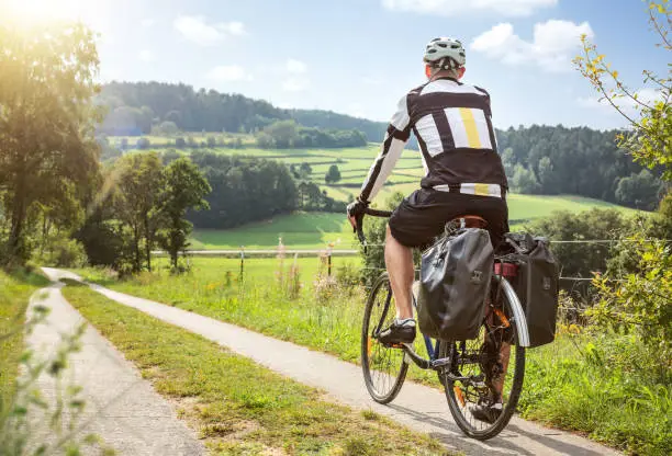 Photo of Cyclist on a touring bike in a green and sunny landscape