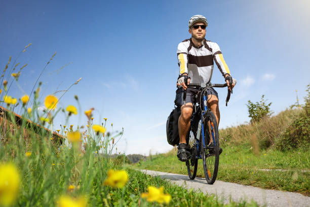 A man wearing a shirt with the colours of Mexico, out on a bike ride in the countryside.