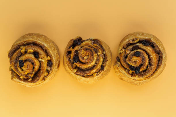 istock Cinnamon, nut and raisin buns on orange background 1202218820