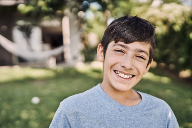 istock Close-up portrait of smiling boy at yard 1202220009