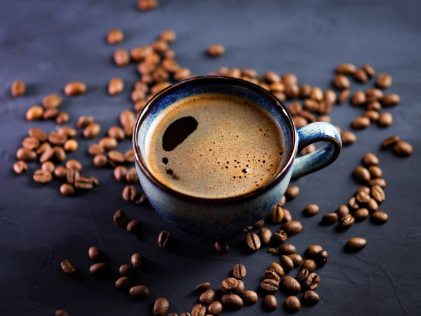 istock Blue Cup of fresh hot espresso coffee on a dark table with coffee beans 1202220218