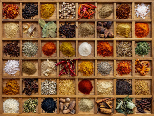 Variety of colorful, organic, dried, vibrant Indian food spices in a wooden compartment box. Many colorful, organic, dried, vibrant Indian food, ingredient spices displayed in a wooden compartment tray. Shot directly above, nice color contrast. pink pepper spice ingredient stock pictures, royalty-free photos & images