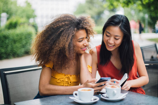 istock Two girlfriends sitting at the cafe and having fun 1202220456