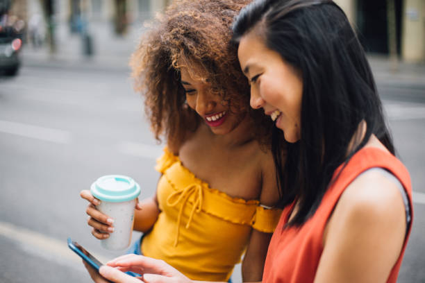 istock Girls using phone and drinking coffee on the street 1202220457