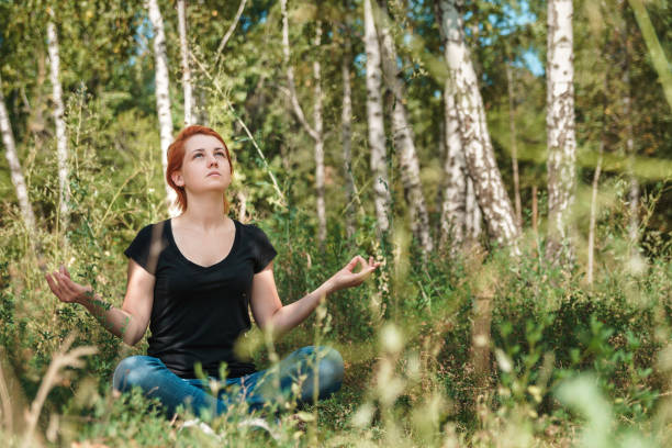 istock Young beautiful meditates in summer green forest. 1202220867
