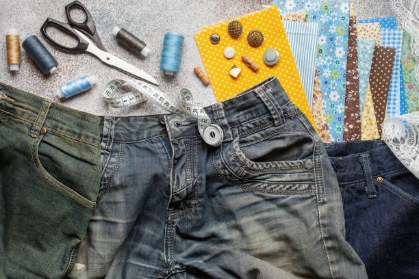 jeans antigos e peças de tecido com acessórios de costura. visão superior. conceito de upcycle. - sewing sewing item thread equipment - fotografias e filmes do acervo