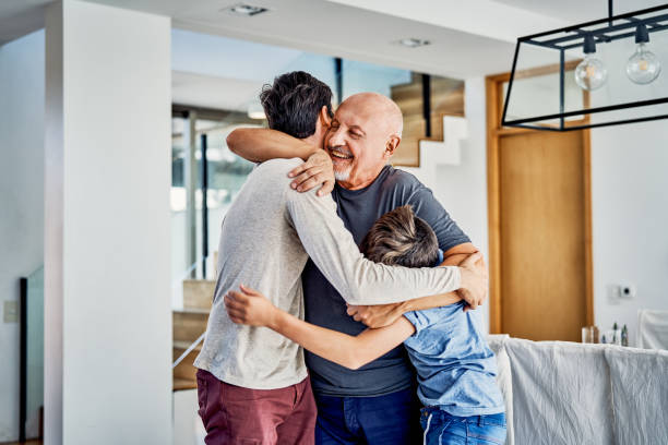 felice famiglia multi-generazione che si abbraccia a casa - grandfather adult affectionate little boys foto e immagini stock