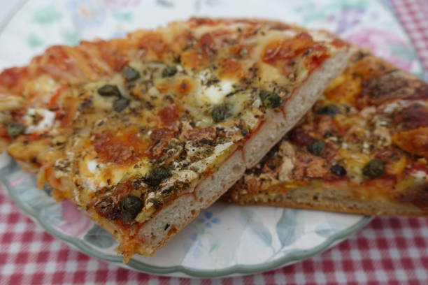 istock Vegetarian pizza in portions on a plate placed on a red gingham tablecloth 1202222218