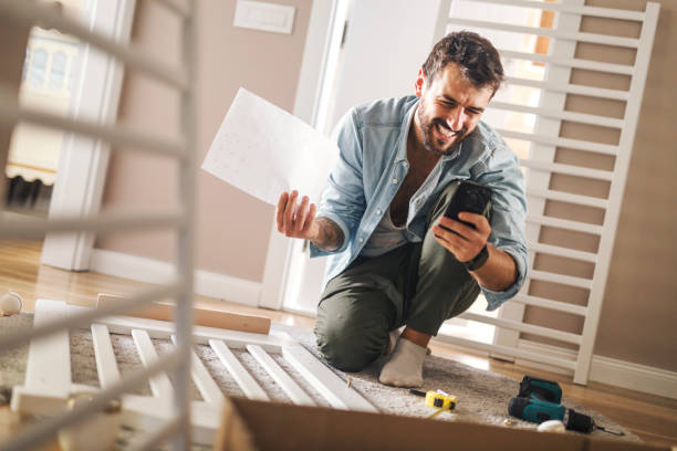 istock Man trying to assemble a baby crib. 1202223447
