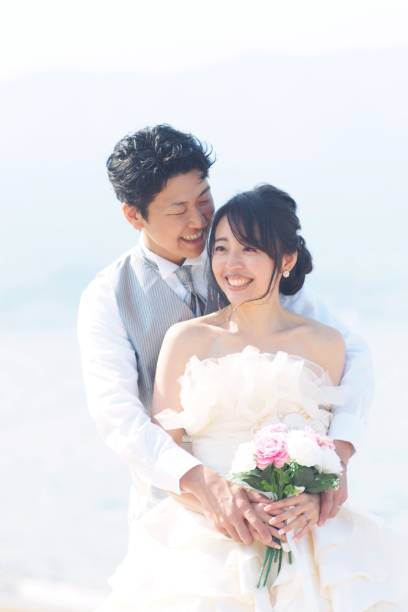 istock Happy bride and groom on the beach 1202224595