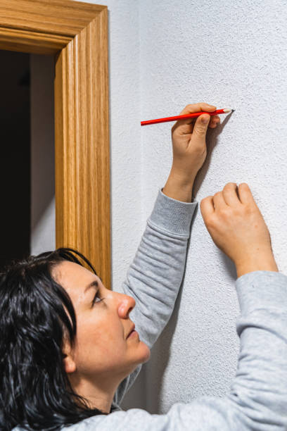 istock A smiling woman marking the white wall 1202225168