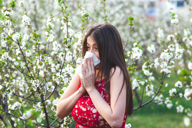 istock Blowing nose in blossoming garden 1202225197