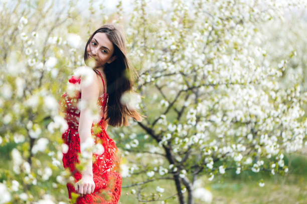 istock Young woman among blooming trees 1202225236