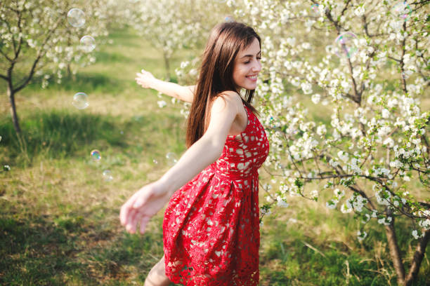 istock Young woman among blooming trees 1202225407