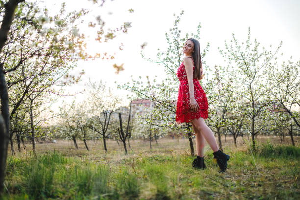 istock Young woman among blooming trees 1202225451