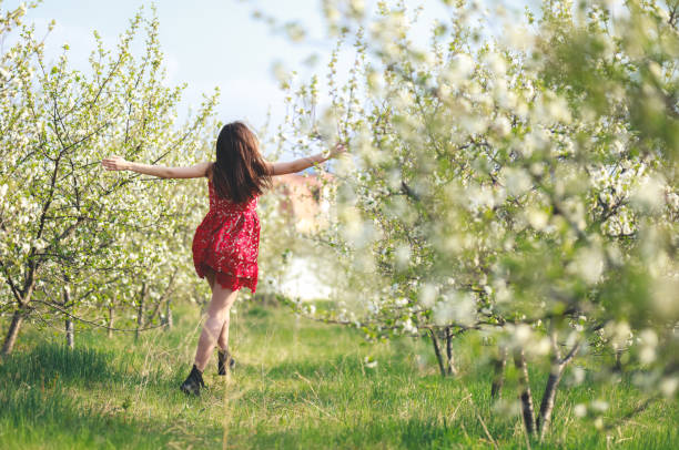 istock Young woman among blooming trees 1202225497