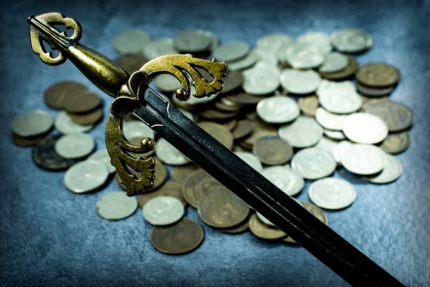 istock Knight's sword on coins background 1202225499