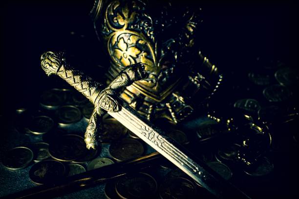 istock Knight's sword and armor on a dark background with coins 1202225510