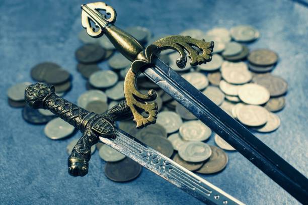 istock Knight's sword on coin background 1202225526