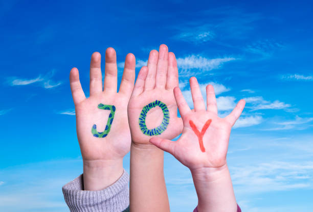 istock Children Hands Building Word Joy, Blue Sky 1202226316